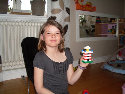 Emma sitter o bygger lego, ett fyrtorn.