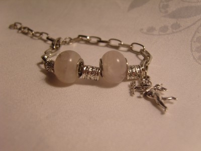 Ett söt armband med kedja, pärlor och en ängel till hänge
