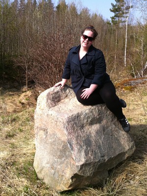 Emelie Bergström välkomnar våren med att sitta på en sten.