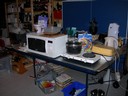 här är det högst tillfälliga köket. i hobbyrummet i källaren på pingisbordet: en mikro, två campingkokplattor och grejer överallt!