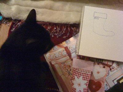 Oskar inspekterar mina planer för julstrumpan.