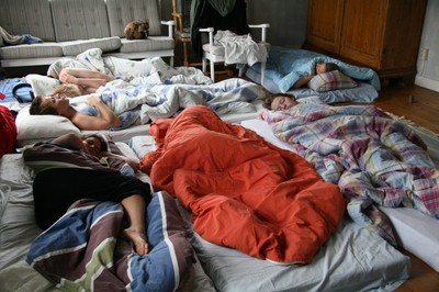 Golvet fyllt med madrasser och sovande ungdomar.