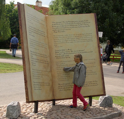 Nioåringen läser en bok vid besöket i Astrid Lindgrens Värld. 