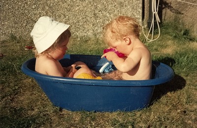 Jag och Alexander badar i en balja på körfältet. Ungefär 2 år gamla.